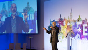 Dan Trommater Magician Speaker on stage with coins in his hands