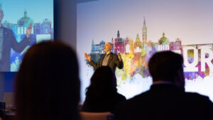 Dan Trommater on stage with audience silhouettes